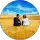Foto de um casal de costas, sentado na areia da praia, olhando para o horizonte. A imagem transmite tranquilidade e reflexão, simbolizando um momento de relaxamento e conexão com o ambiente, ideal para ilustrar comentários ou resenhas de experiências relaxantes.